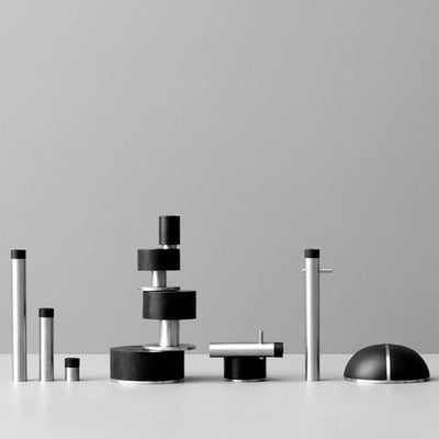 A group of d line Knud Wall Door Stops, in black and white, sitting on top of a table.