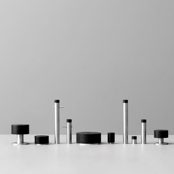 A group of d line Knud Wall Door Stops, in black and white, sitting on top of a table.