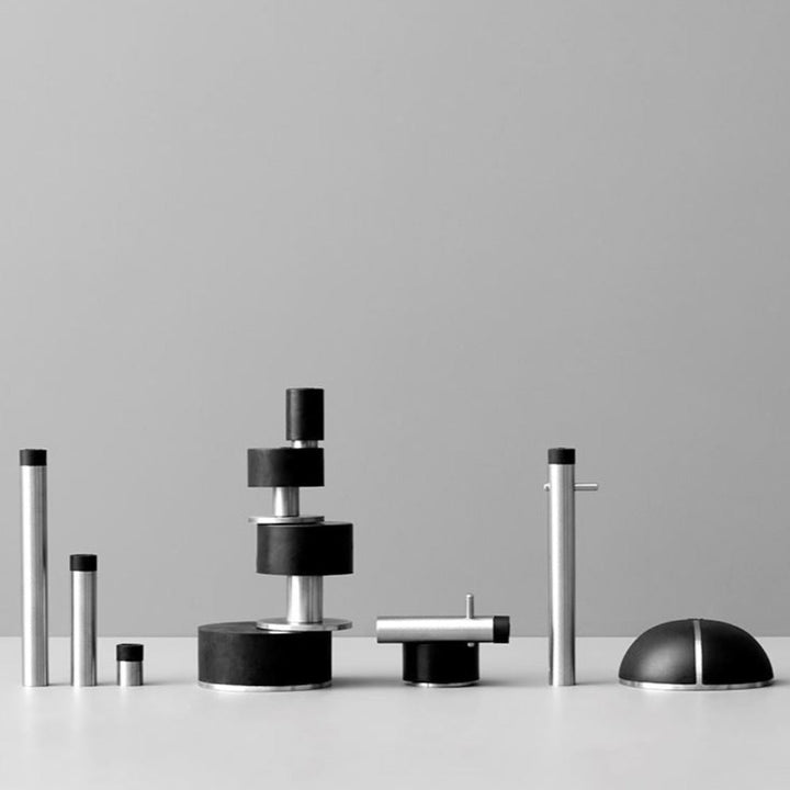 A group of d line Knud Wall Door Stops with Coat Pins, in black and white, sitting on top of a table.