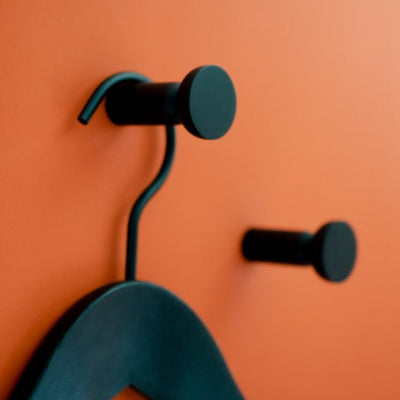 Round hook in black aluminum mounted on wall