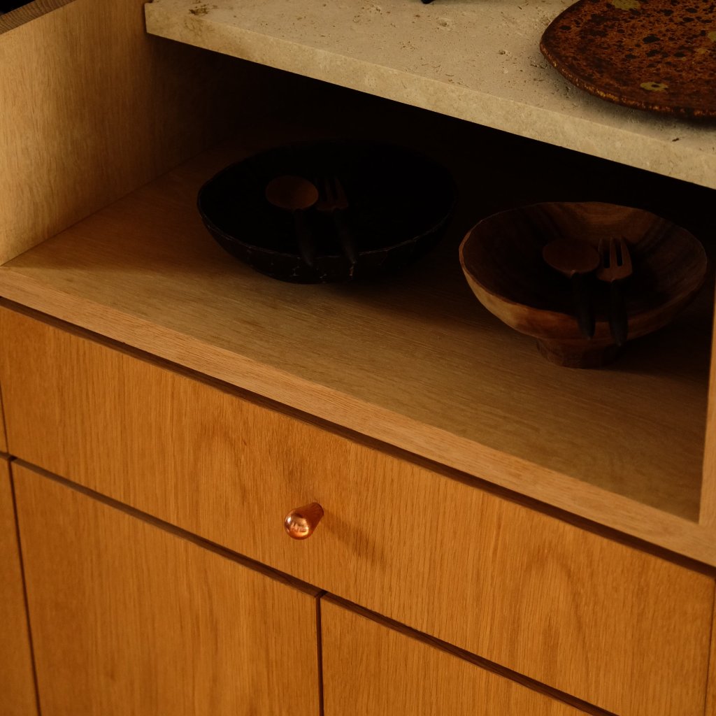 Copper Maha Alavi LUA knob on a wood cabinet.