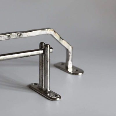 A set of Mi & Gei Libre Forme No. 15 Towel Bar brackets sitting on top of a table.