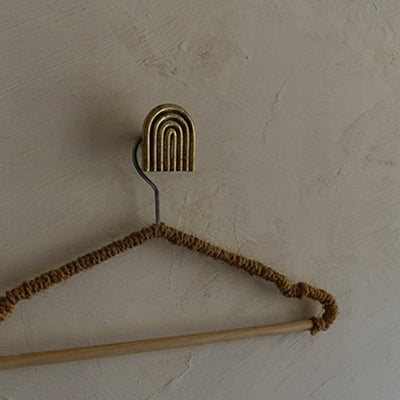 A Mi & Gei Libre Forme No. 9 Hook clothes hanger with a wooden stick attached to it.