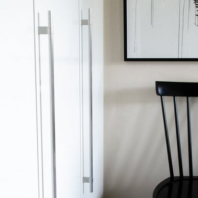 A black Line Big Handle chair sitting in front of a white Baccman Berglund refrigerator.