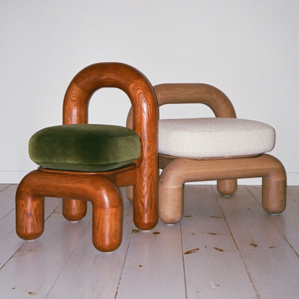 Lithic dining chair in red oak and natural oak side by side on wooden floor