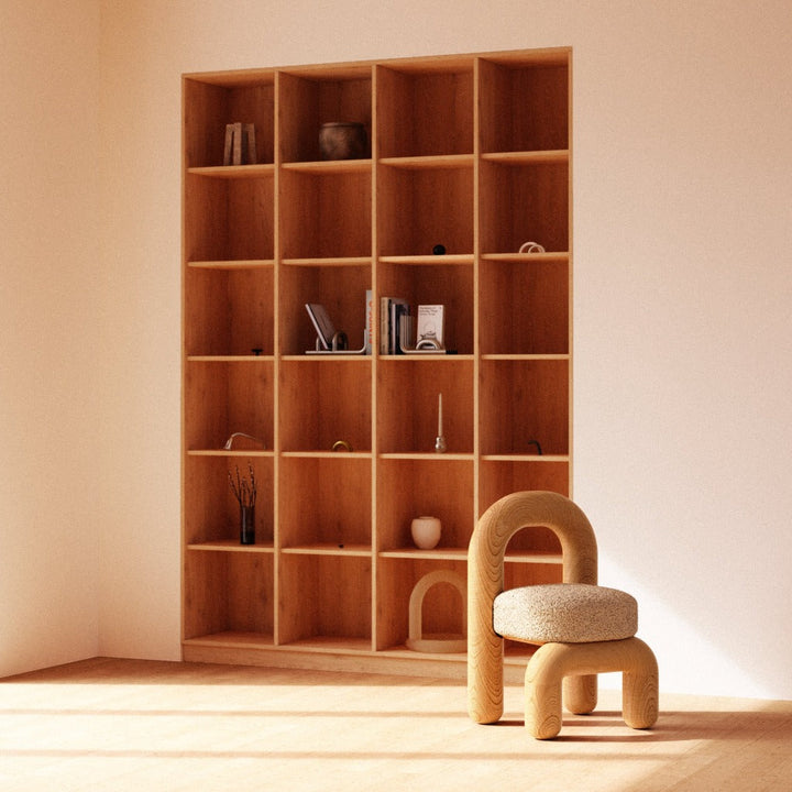 Lithic dining chair in natural oak with beige upholstery in front of wooden shelf