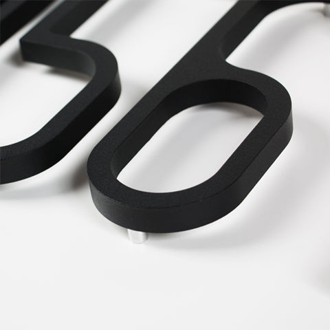 A close up of a LIXHT Aluminum Numbers Large on a white surface.