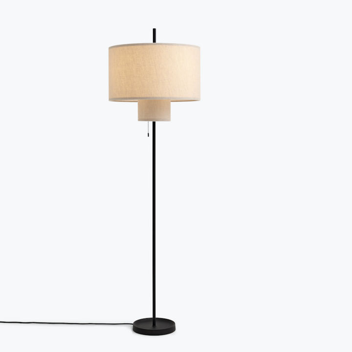 A round, tiered floor lamp with a thin black base