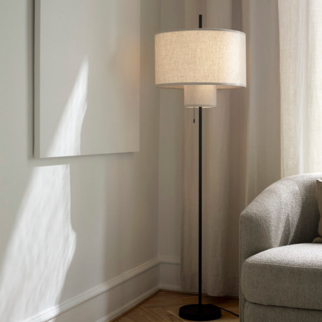 A round, tiered floor lamp with a thin black base