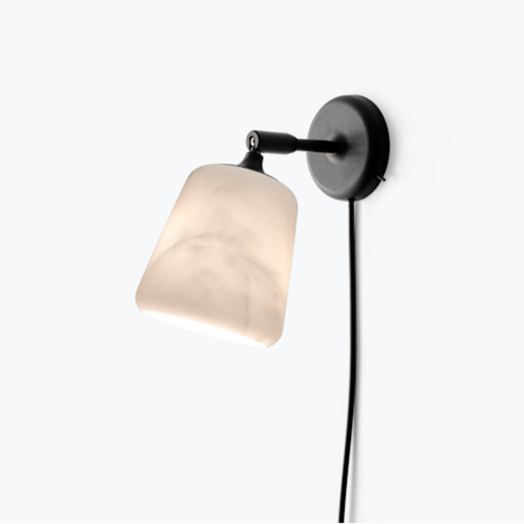 Minimalist wall lamp with a matte black frame and a translucent, textured marble shade on a pivoting arm.
