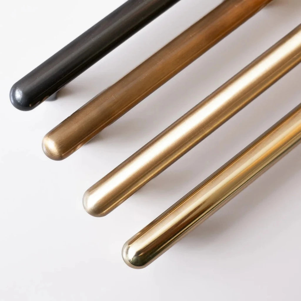 Chapman & Bose metal bar pulls stacked in black and brass finishes.