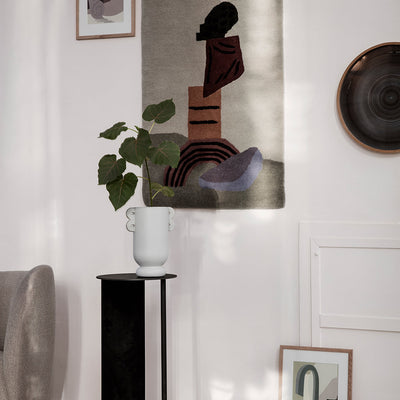A Ferm Living Muses Vase Ania with a plant in it sitting on a stand.