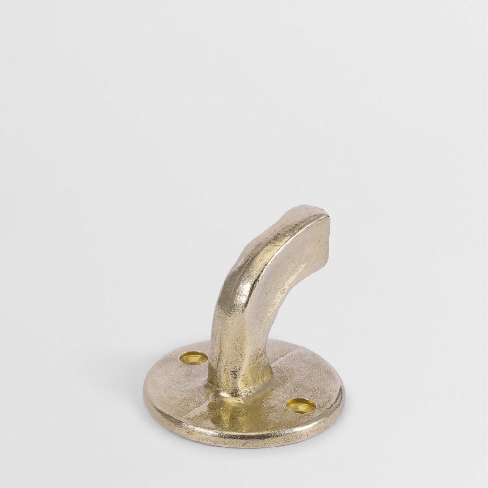 Hand-cast solid brass Forme No. 8 hook with a curved, sculptural profile and textured matte finish on a white background.