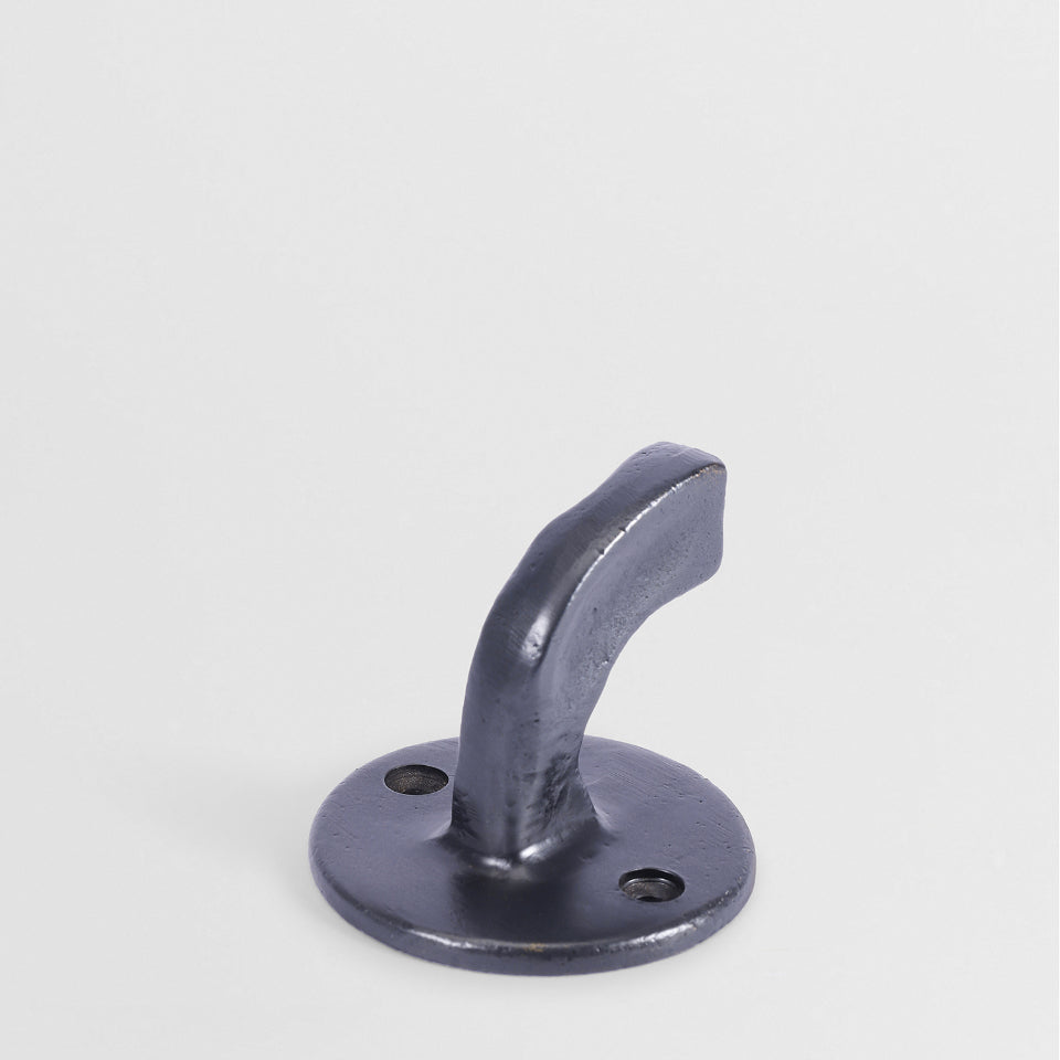 Sculptural bronze Forme No. 8 wall hook with a hand-cast, textured finish and curved architectural profile.
