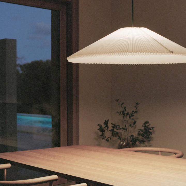 Large pendant lamp hung over wooden dining table