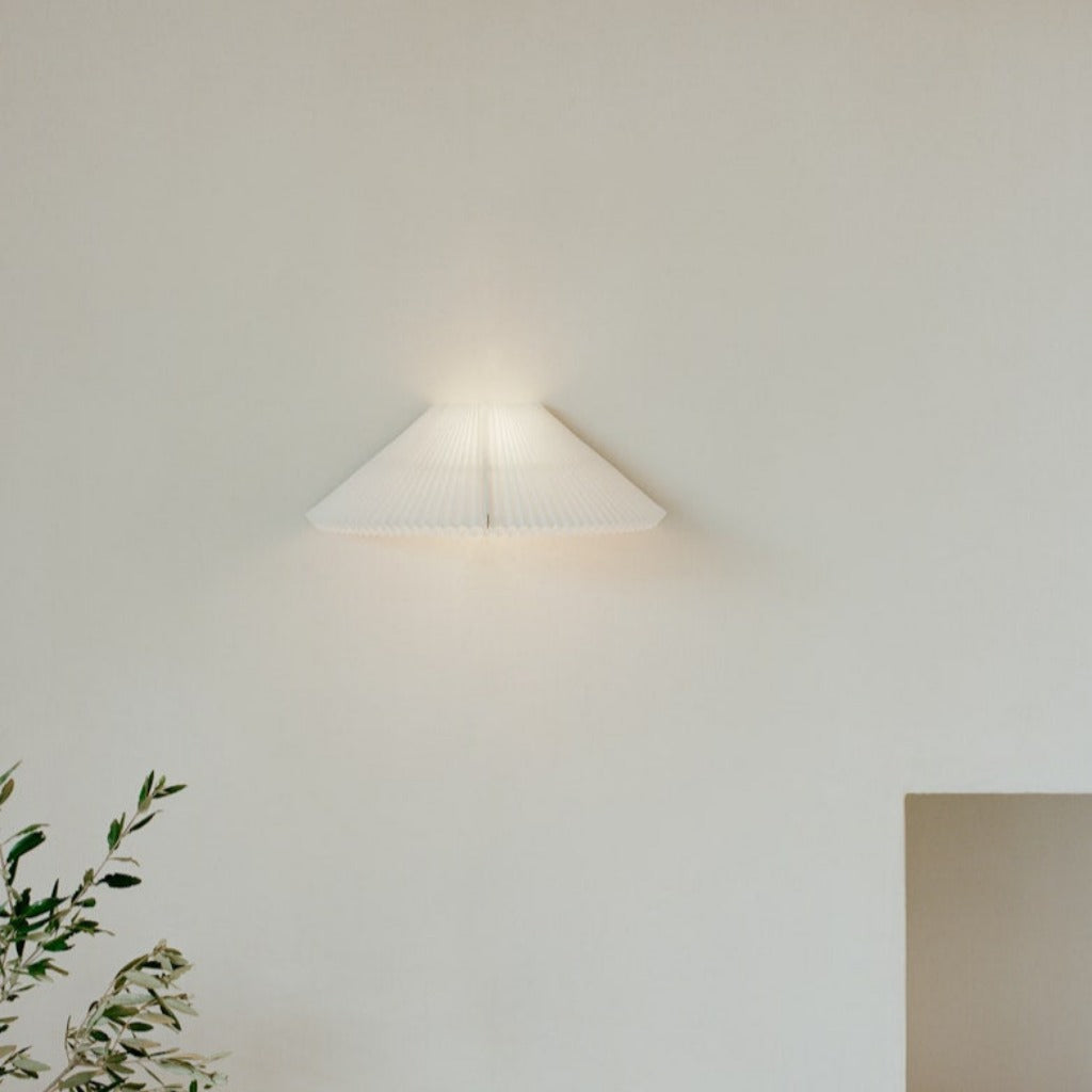 A white, pleated wall lamp