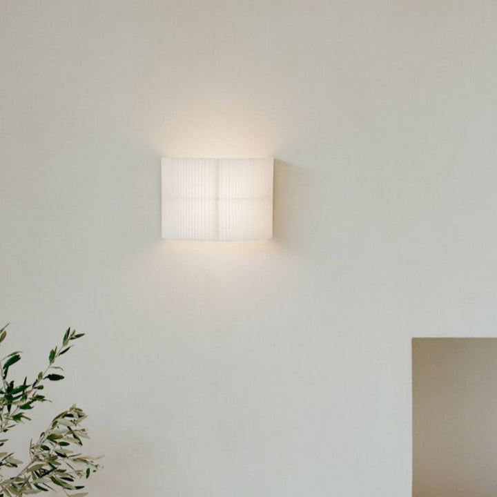 A white, pleated wall lamp