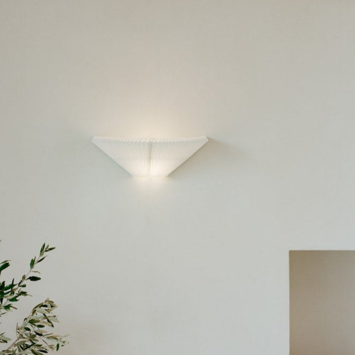 A white, pleated wall lamp