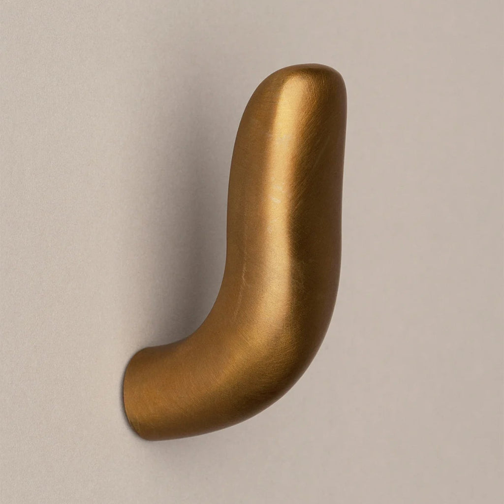 Softly curved J shaped hook in amber brass, side view.