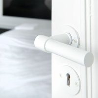 A close up of a Formani ONE by Piet Boon door lever on a white door.