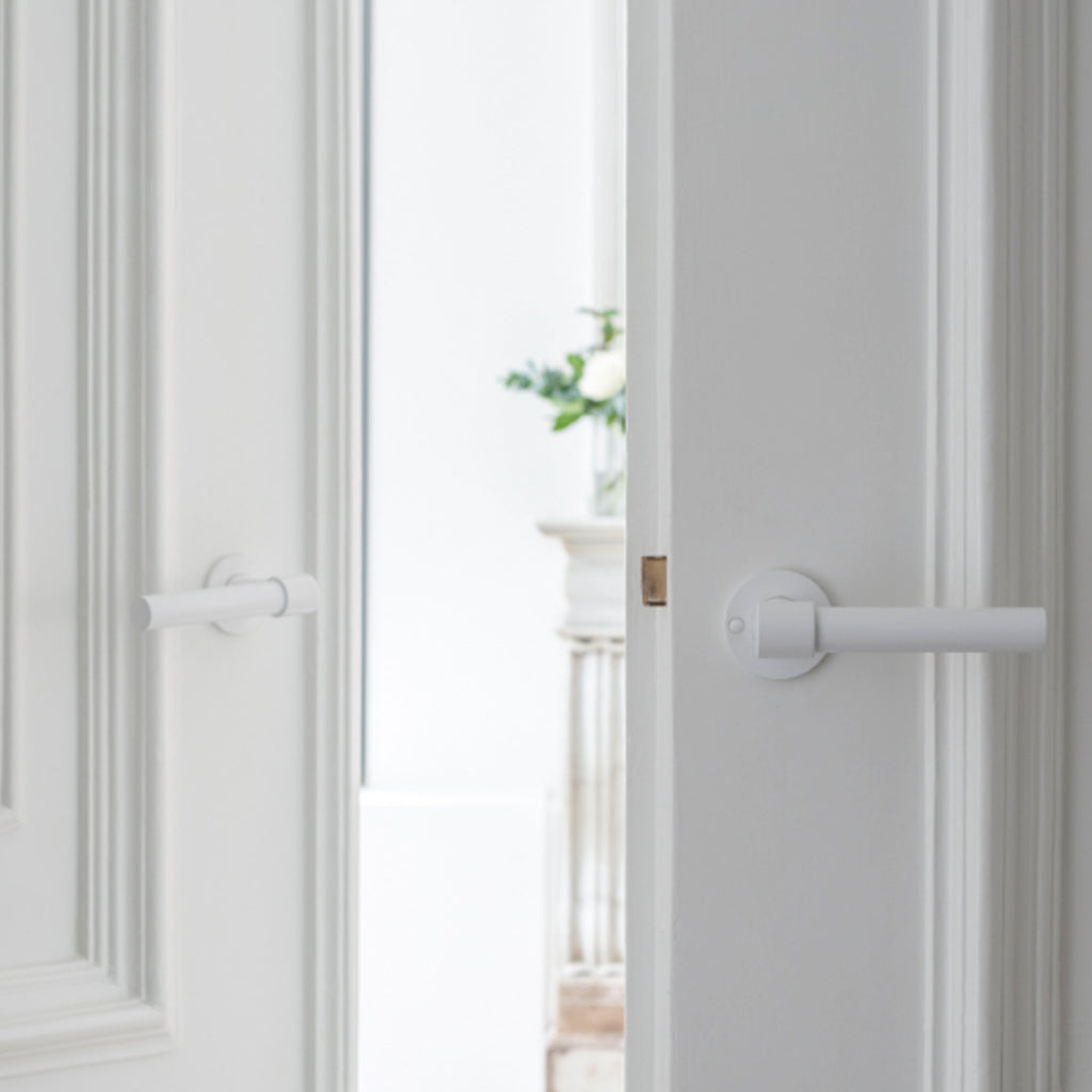 A white Formani door with a ONE by Piet Boon Door Lever handle on it.