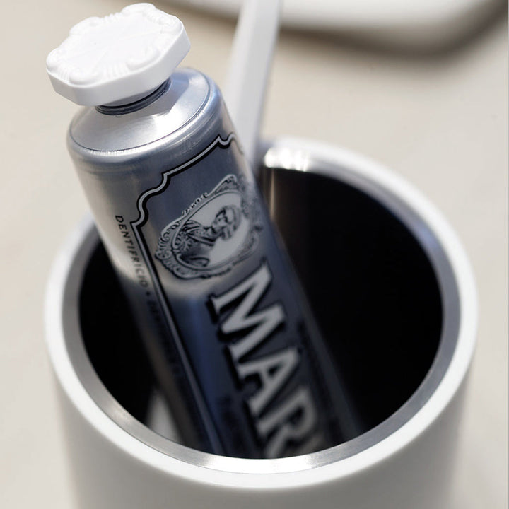 A Formani ONE by Piet Boon Toothbrush Holder and tube in a cup on a table.