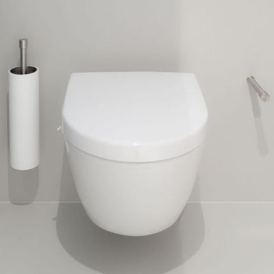 A Formani ONE by Piet Boon Wall Mounted Toilet Brush Holder sitting next to a roll of toilet paper.
