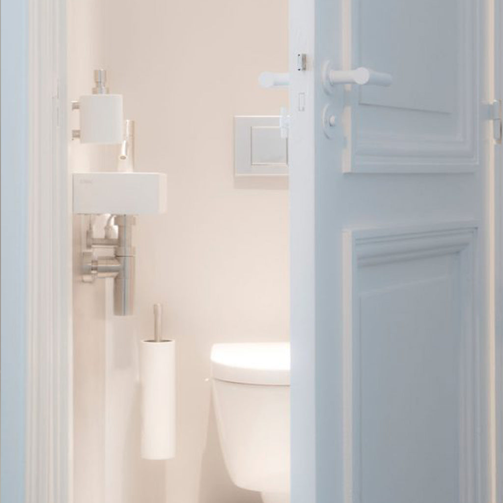 An ONE by Piet Boon Wall Mounted Toilet Brush Holder sitting next to a white sink. (Brand name: Formani)