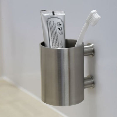 A Formani ONE by Piet Boon Wall Mounted Toothbrush Holder with toothpaste and toothbrush in it.