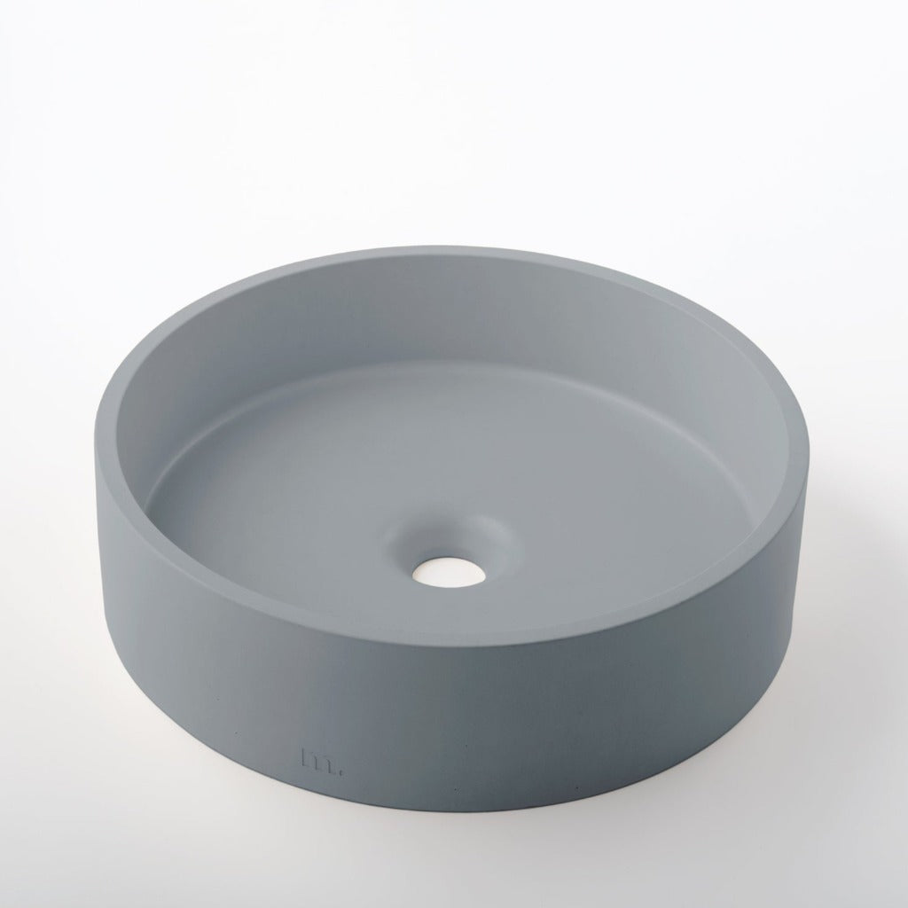 A mudd. concrete Odet Basin LG sink on a white surface.