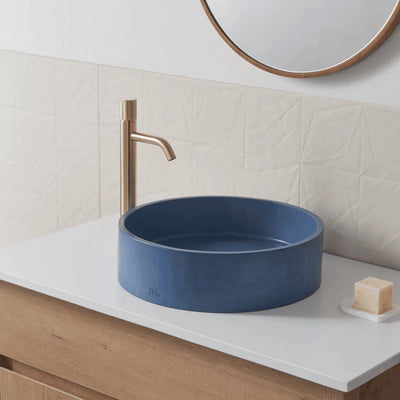 Circular wash basin with dark blue finish mounted on vanity