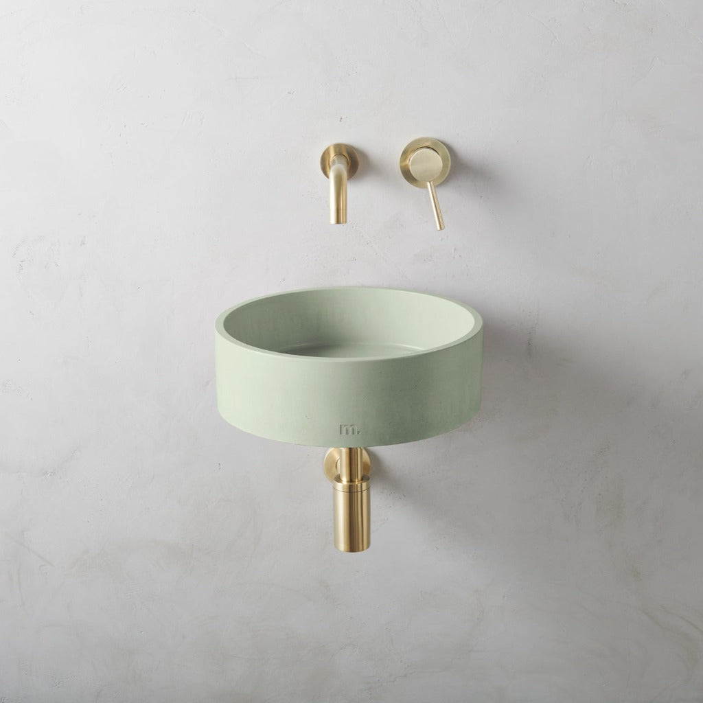 A Mudd. Concrete Odet Basin SM Affix with a gold faucet next to it.