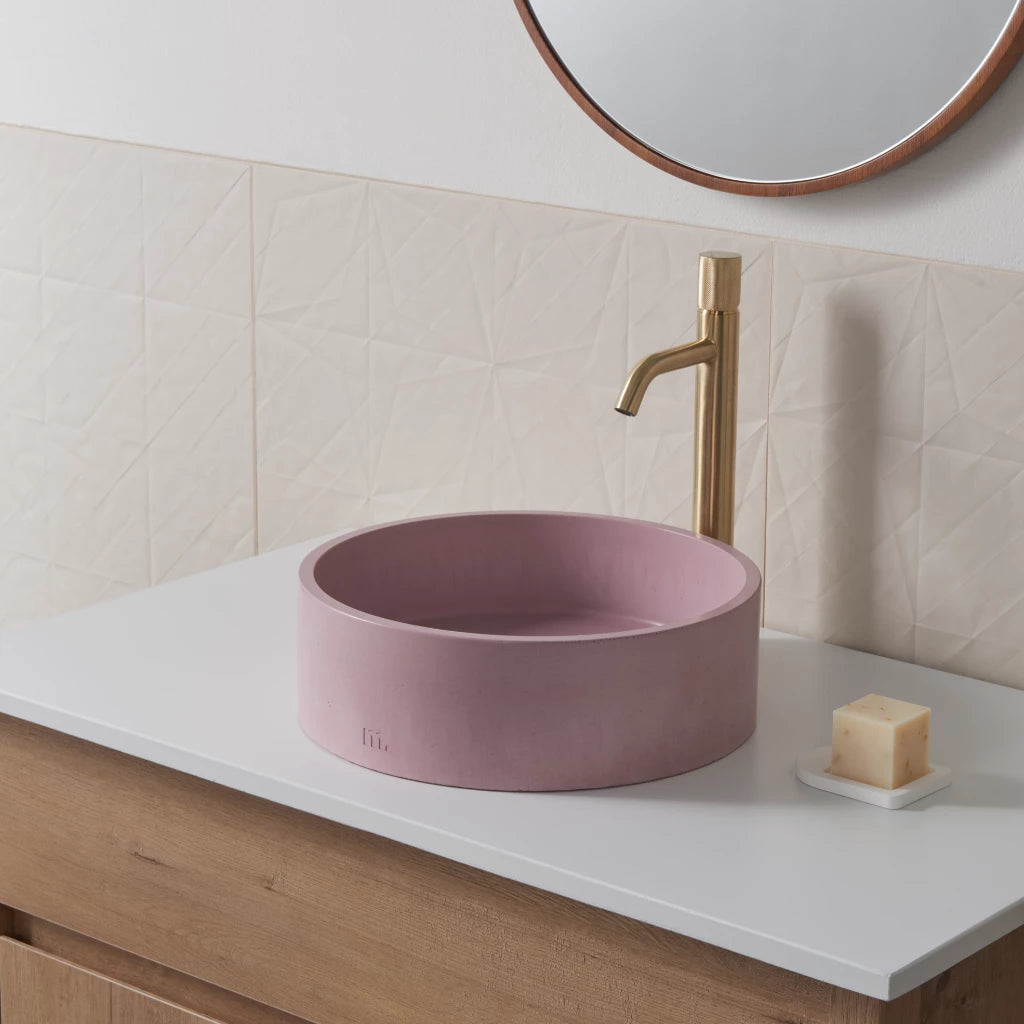 Circular wash basin with light pink finish mounted on vanity