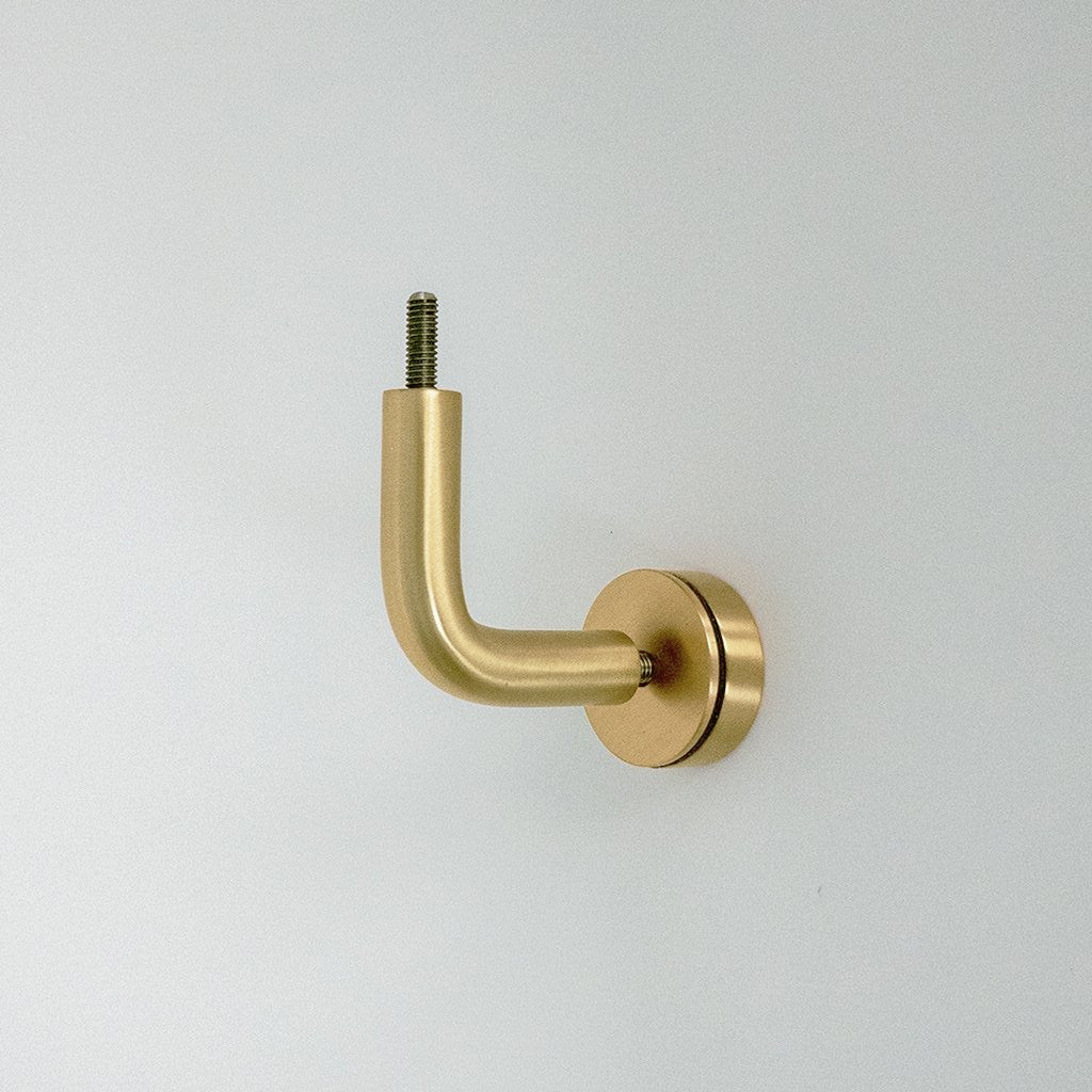 A CBH Orla Handrail Bracket on a white wall with a screw.