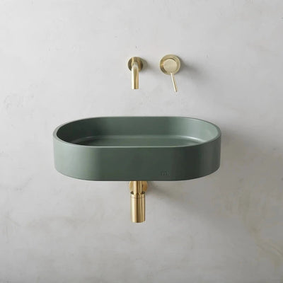 A Parro Basin LG Affix from mudd. concrete with a gold faucet next to it.