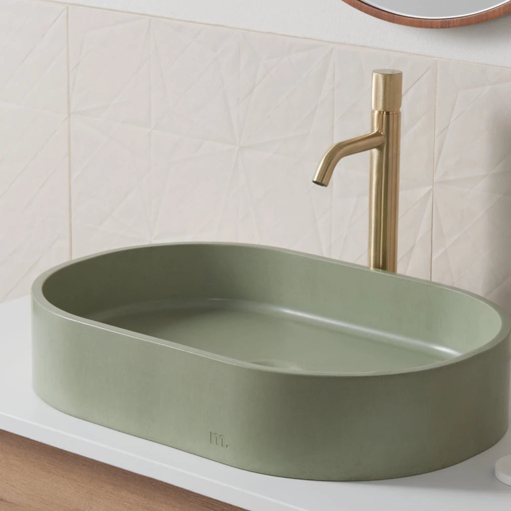 A Parro Basin LG by mudd. concrete with a gold faucet on top of it.