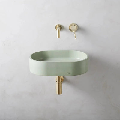 A Parro Basin SM Affix by mudd. concrete sitting next to a wall mounted faucet.