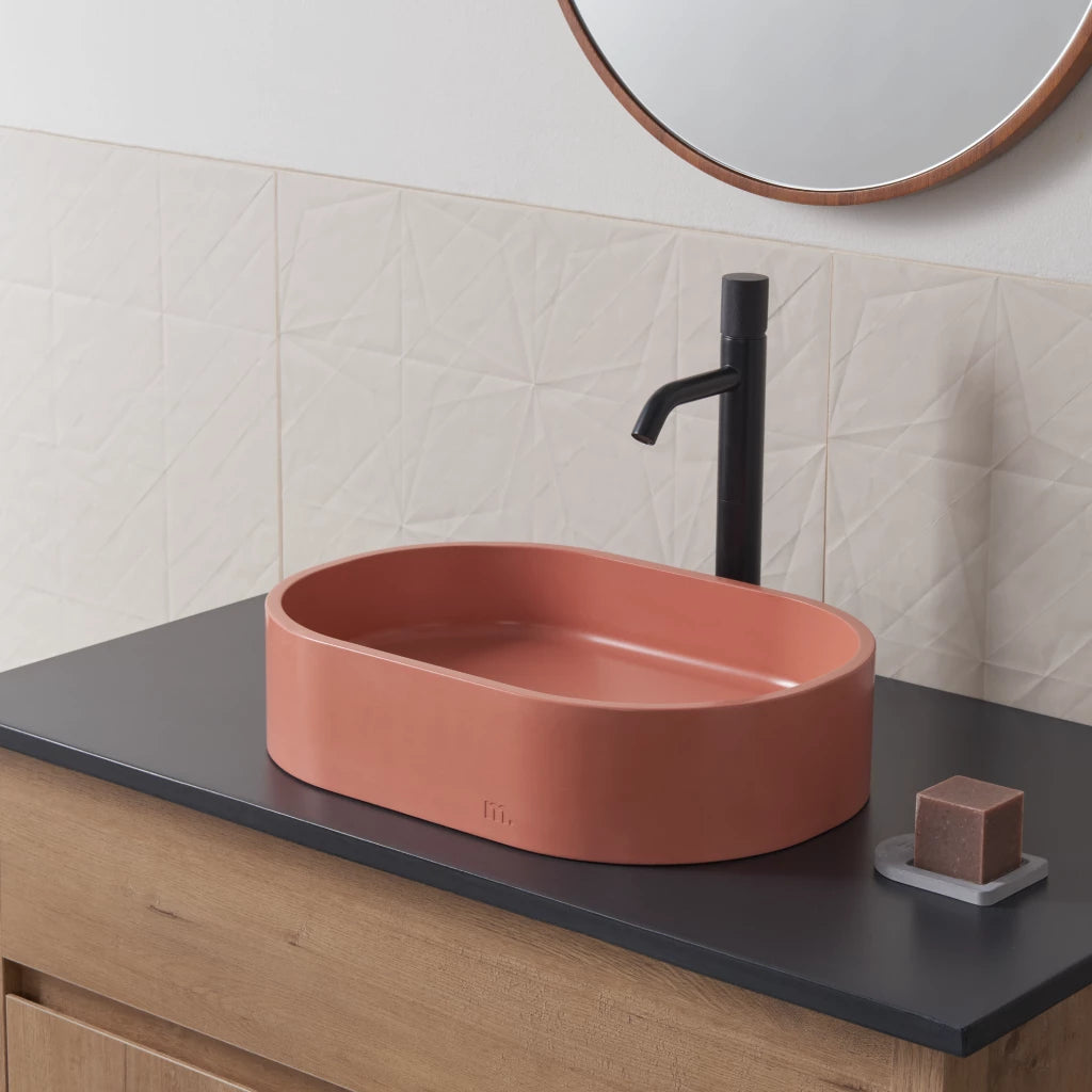 Oval wash basin with pink finish mounted on vanity