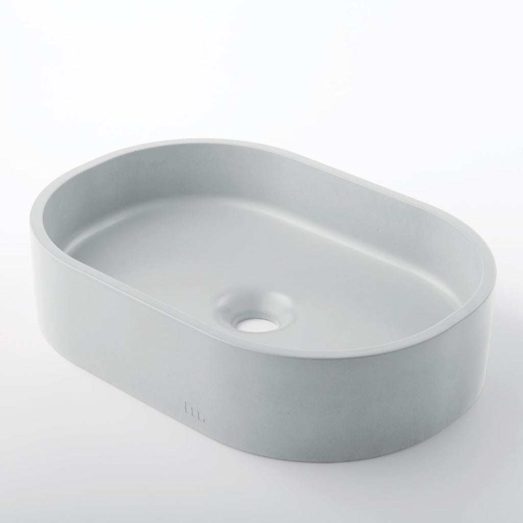 A Parro Basin SM sink sitting on top of a white mudd. concrete counter.