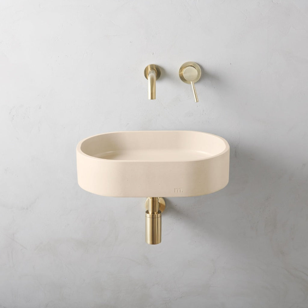 A white Parro Basin SM Affix by mudd. concrete sitting next to a wall mounted faucet.
