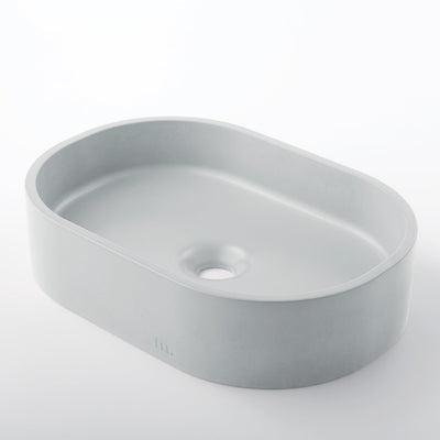 A Parro Basin SM sink sitting on top of a white mudd. concrete counter.