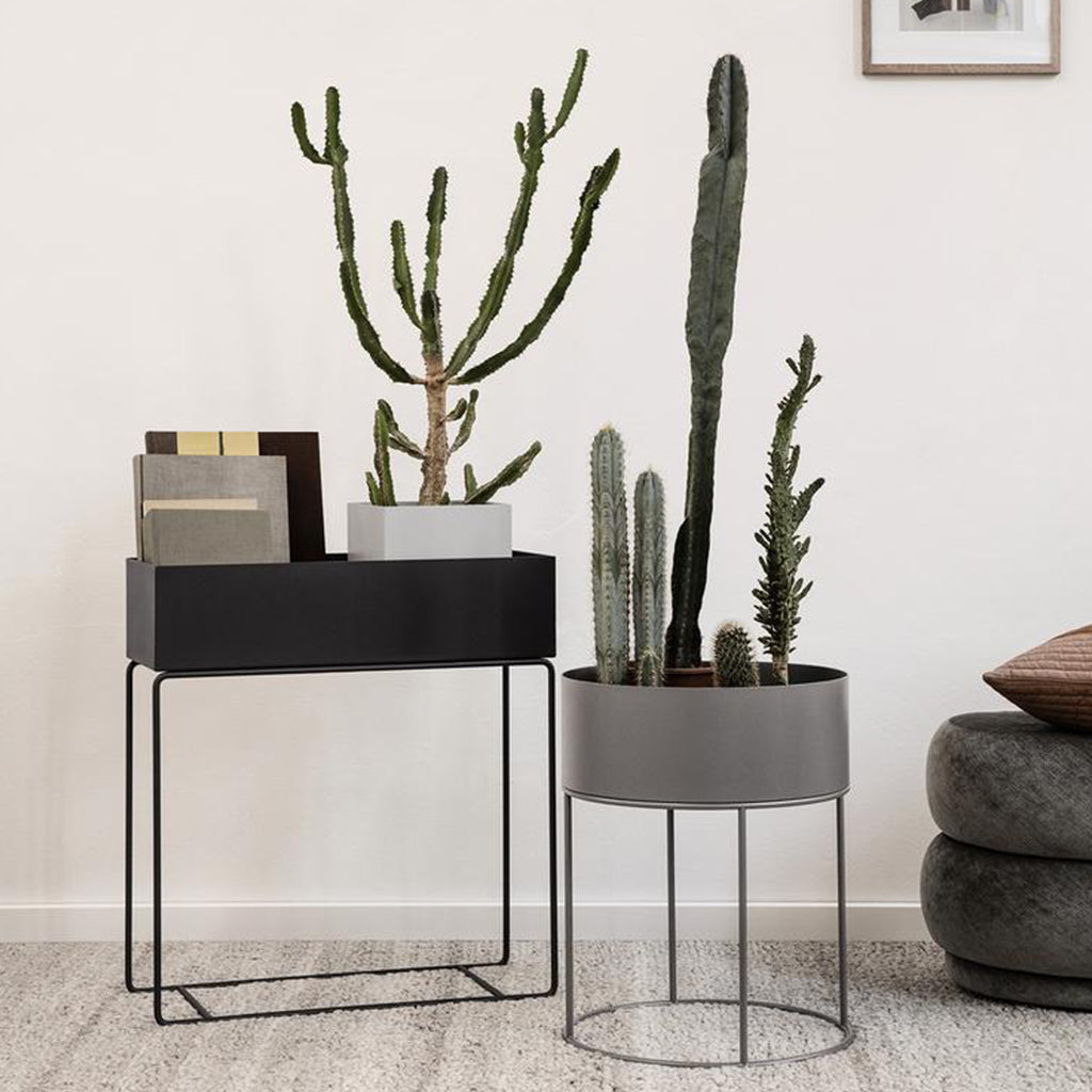 A couple of Ferm Living Plant Box Rounds sitting on top of a table.