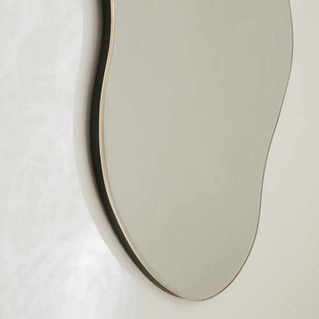 A Ferm Living Pond Mirror Large hanging on a wall.
