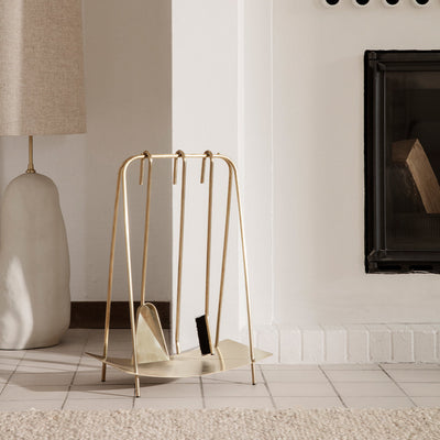Port Fireplace Tools by Ferm Living sitting on top of a table next to a lamp.