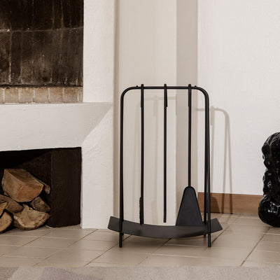 A Ferm Living Port Fireplace Tools set with a fireplace and a black sculpture.
