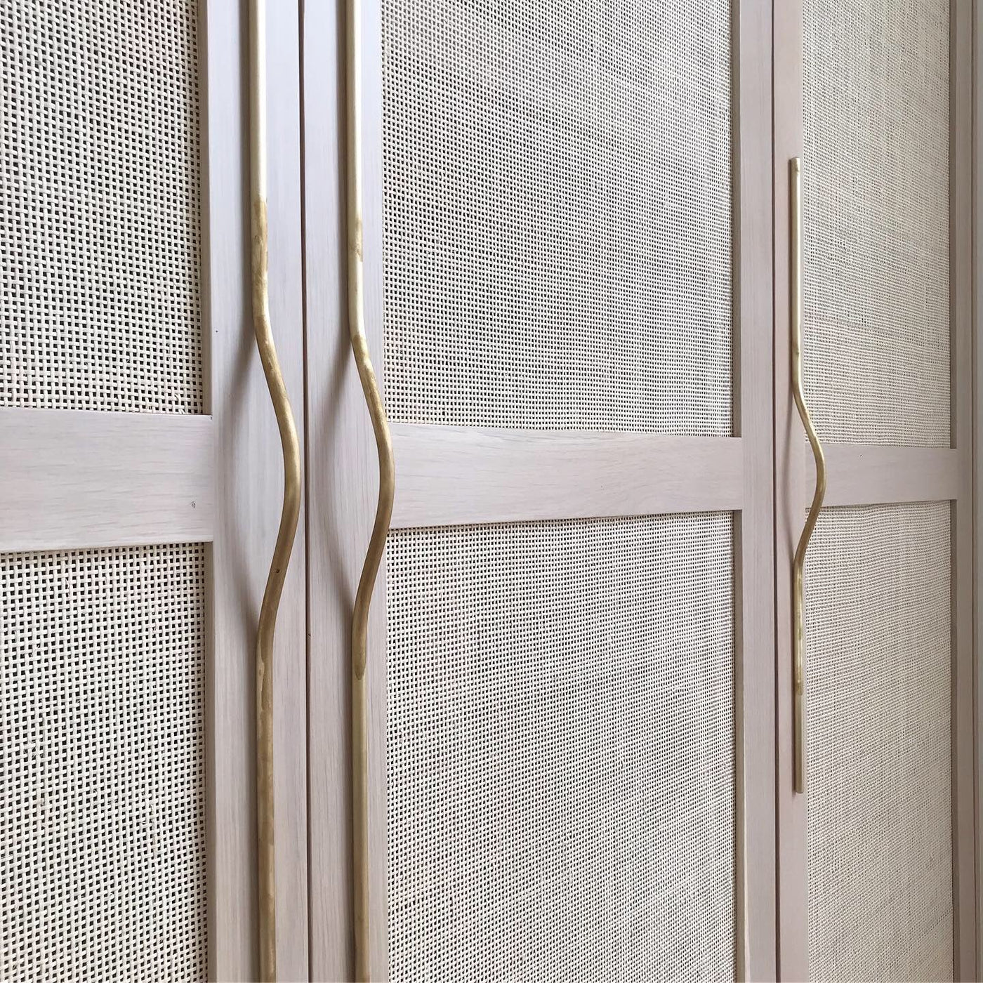 A close up of a white cabinet with Jeroen van de Gruiter's Pulse Line Handles in gold.