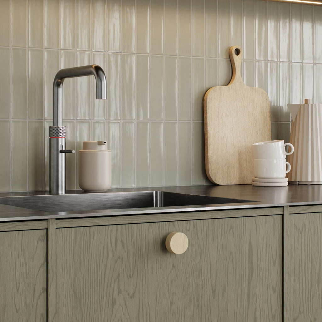 Nordic oak Furnipart Row cabinet knob on a pale green oak cabinet door.
