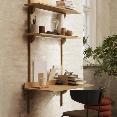 A corner of a room with a Ferm Living Sector Desk and a chair.