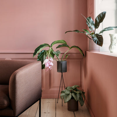 A living room with pink walls and two Ferm Living Sekki Pots.