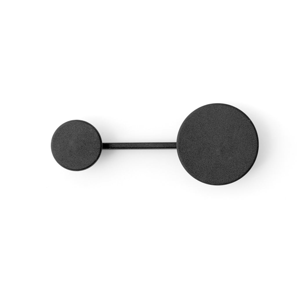 A black object with two circles on it is the Audo Small Afteroom Coat Hanger.